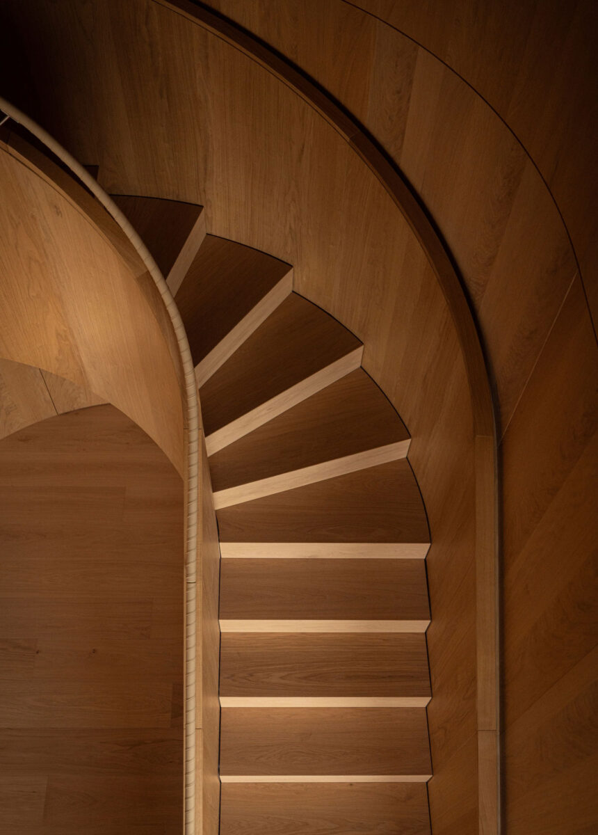 Architectural staircase with warm wood finishes in a contemporary luxury apartment