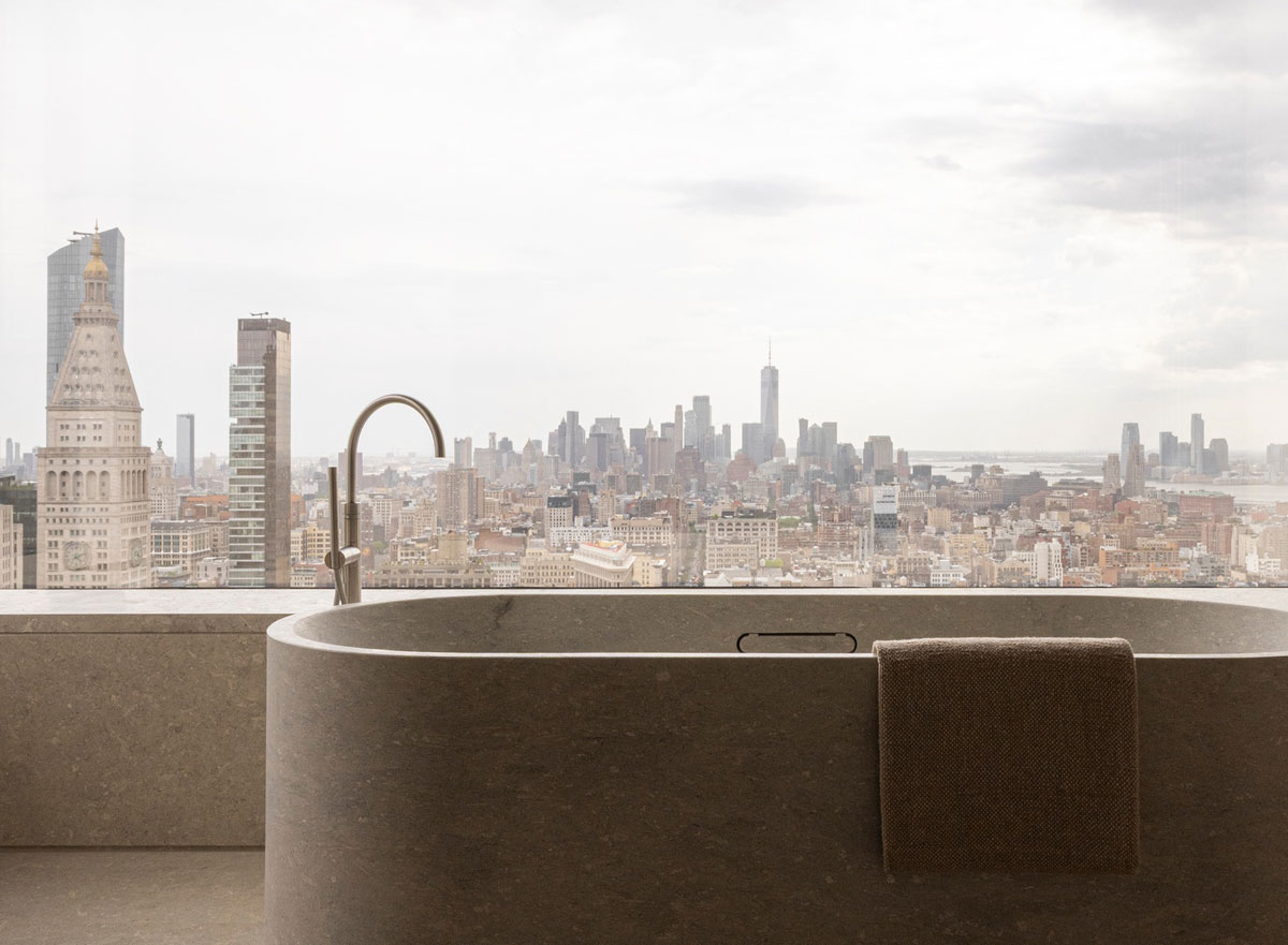 Norm Architects bathroom with monolithic Grigio Alpi marble bathtub