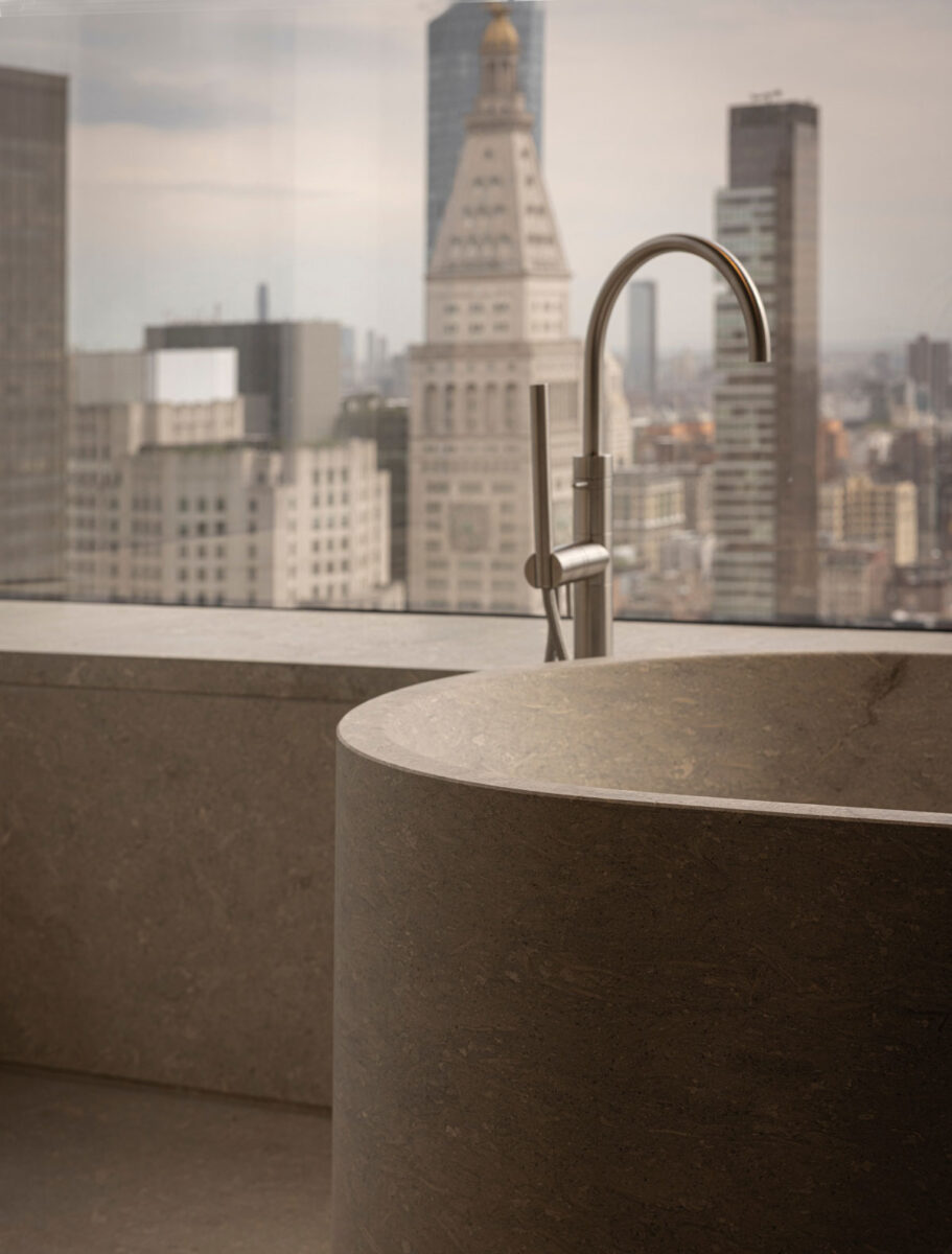 Grigio Alpi marble bathroom with sculptural stone bathtub by Norm Architects
