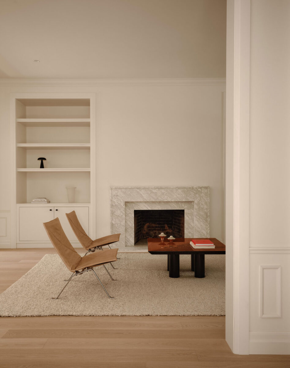 Elegant Montreal living room with marble fireplace, built-in shelving and mid-century lounge chairs
