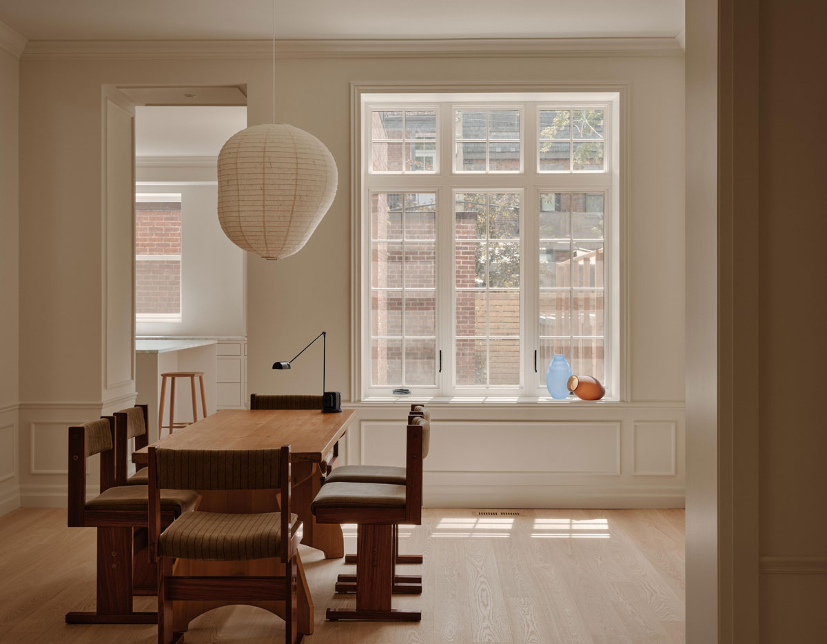 Wood Residence dining room with dark wood table, sculptural pendant light and white oak flooring