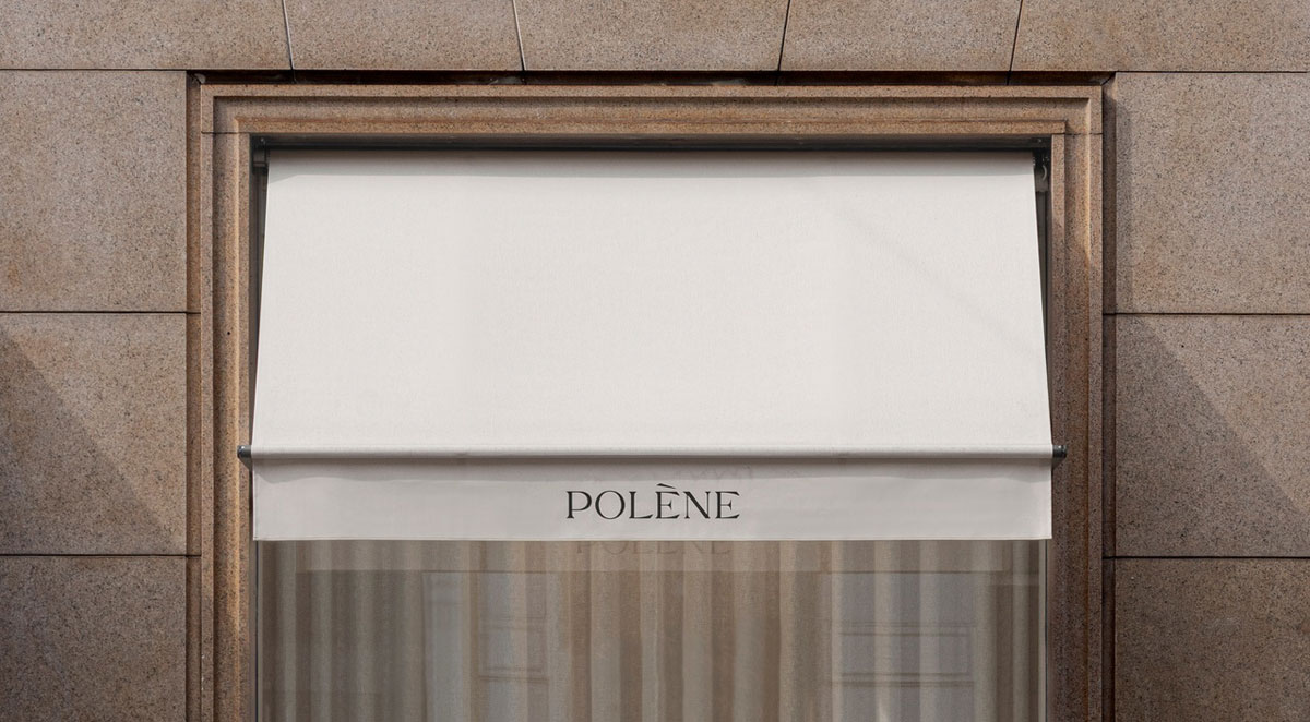 White awning and stone-framed window at the Polène Milan flagship store designed by Norm Architects.
