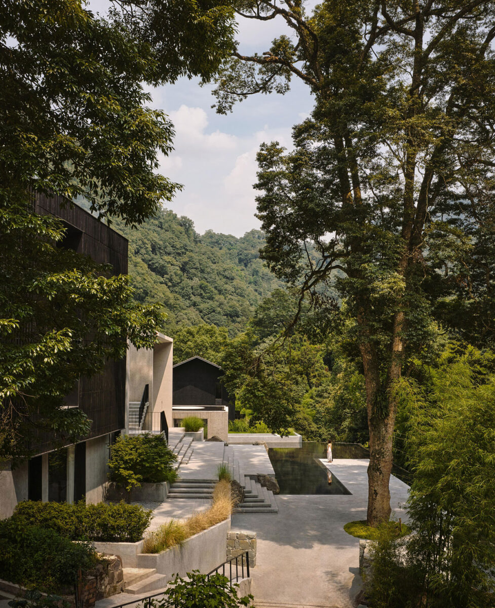 Luxury hillside resort and pool surrounded by mature trees and lush mountain landscaping